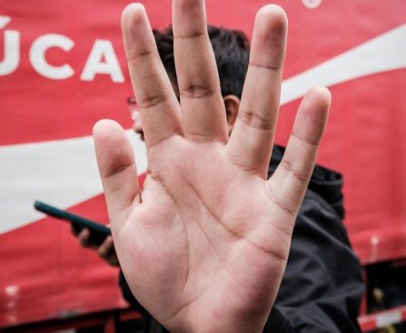 a person with their hand up in front of a coca - cola truck